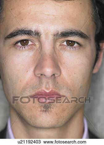 Stock Image - Close up portrait of young man's face, serious expression, Alicante, Spain,. Fotosearch