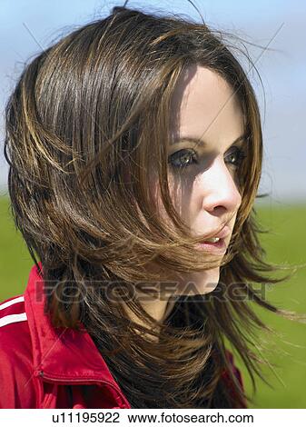 Stock Image - Woman outdoors looking out at something.. Fotosearch