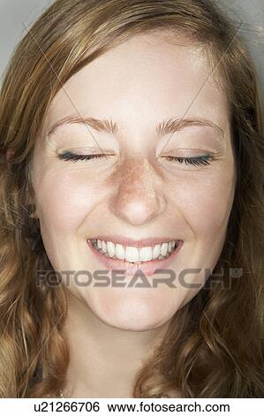Young female with eyes closed smiling View Large Photo Image Stock Photograph - Young female with eyes closed smiling. Fotosearch