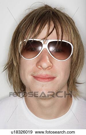 Stock Photo - Young male smiling wearing sunglasses. Fotosearch
