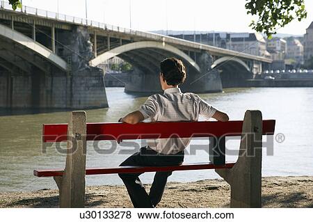 Businessman sitting alone on Bench by river. View Large Photo Image Stock Photo - Businessman sitting alone on Bench by river.. Fotosearch