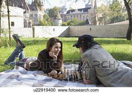 Couple playing chess in a park smiling. View Large Photo Image Stock Image - Couple playing chess in a park smiling.. Fotosearch