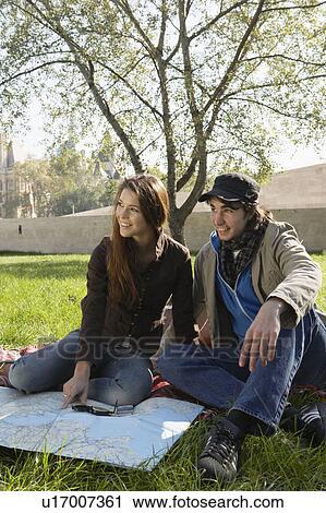 Couple with a map and compass in a park smiling. View Large Photo Image Stock Image - Couple with a map and compass in a park smiling.. Fotosearch