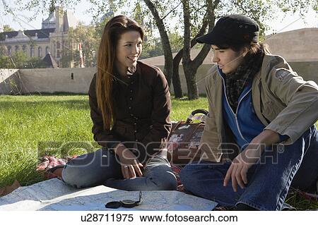 Couple with a map and compass in a park smiling. View Large Photo Image Stock Photography - Couple with a map and compass in a park smiling.. Fotosearch