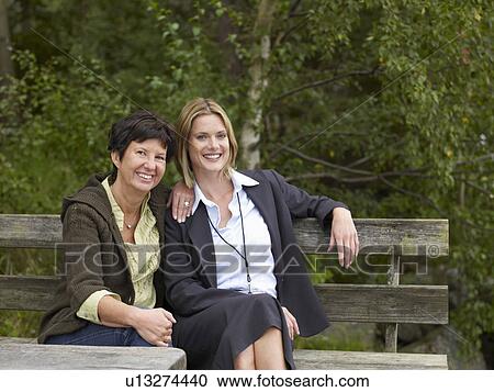 Mother and daughter sitting on bench View Large Photo Image Stock Image - Mother and daughter sitting on bench. Fotosearch