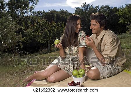 Stock Image - Young couple sharing fresh fruit . Fotosearch