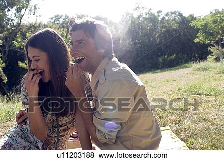 Stock Photo - Young couple sharing fresh fruit. Fotosearch