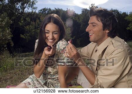 Young couple sharing fresh fruit View Large Photo Image Stock Photo - Young couple sharing fresh fruit . Fotosearch