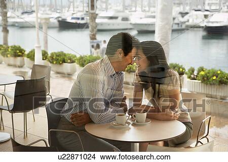 Couple being affectionate in a restaurant. View Large Photo Image Picture - Couple being affectionate in a restaurant.. Fotosearch