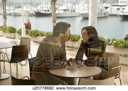 Couple being affectionate in a restaurant. View Large Photo Image Stock Image - Couple being affectionate in a restaurant.. Fotosearch