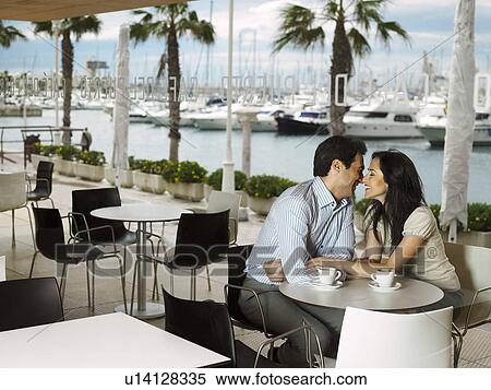 Couple being affectionate in a restaurant. View Large Photo Image Stock Photography - Couple being affectionate in a restaurant.. Fotosearch