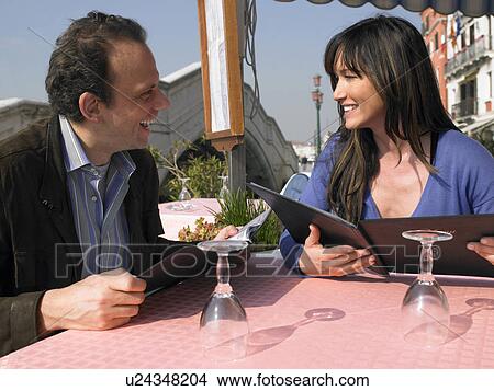 Couple looking at menu at outdoor restaurant. Venice, Italy. View Large Photo Image Picture - Couple looking at menu at outdoor restaurant. Venice, Italy.. Fotosearch