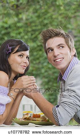 Stock Image - Man and woman holding hands.. Fotosearch