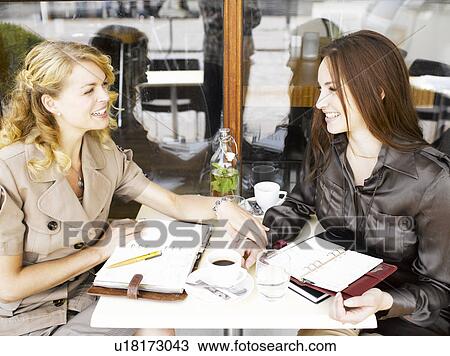 Stock Image - Two women at an outdoor restaurant. Fotosearch