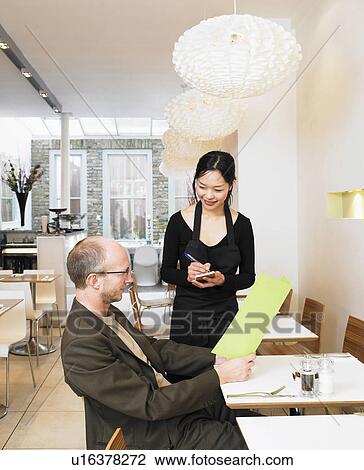 Waitress taking order from mature man in restaurant View Large Photo Image Stock Image - Waitress taking order from mature man in restaurant. Fotosearch
