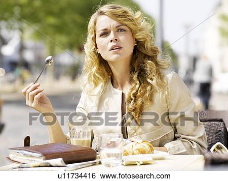 Woman eating at an outdoor restaurant View Large Photo Image Stock Photograph - Woman eating at an outdoor restaurant. Fotosearch