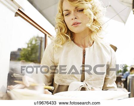Woman taking notes at an outdoor restaurant View Large Photo Image Stock Image - Woman taking notes at an outdoor restaurant. Fotosearch