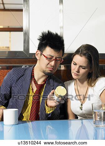 Young man and woman reading ingredients on a jar in a diner View Large Photo Image Picture - Young man and woman reading ingredients on a jar in a diner. Fotosearch