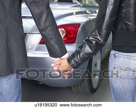 Couple holding hands in front of a convertible close up. View Large Photo Image Stock Image - Couple holding hands in front of a convertible close up.. Fotosearch