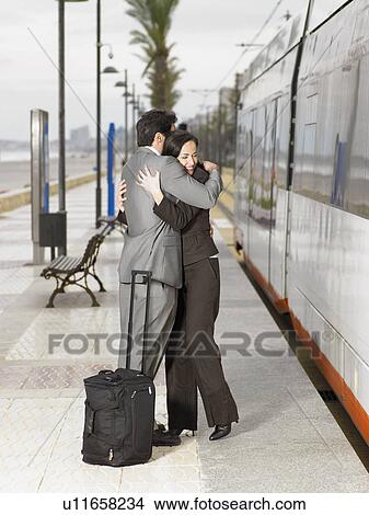 Couple in suits embracing at tram stop next to tram. Alicante, Spain. View Large Photo Image Picture - Couple in suits embracing at tram stop next to tram. Alicante, Spain.. Fotosearch