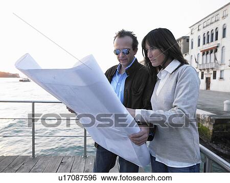 Couple looking at architect's blueprint. Venice, Italy. View Large Photo Image Stock Photograph - Couple looking at architect's blueprint. Venice, Italy.. Fotosearch
