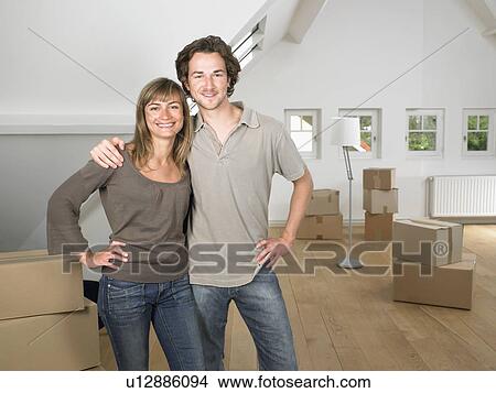 Picture - Couple moving into new home smiling.. Fotosearch