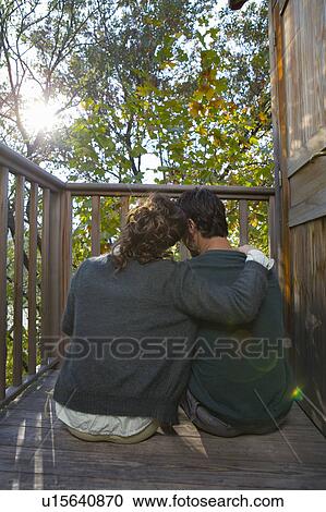 Stock Image - Couple outdoors on balcony being affectionate.. Fotosearch