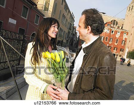 Man giving flowers to woman. Venice, Italy. View Large Photo Image Stock Photograph - Man giving flowers to woman. Venice, Italy.. Fotosearch