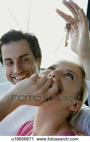 Portrait of a couple holding keys. View Large Photo Image Stock Image - Portrait of a couple holding keys.. Fotosearch