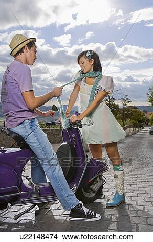 Woman flirting with man on scooter. View Large Photo Image Picture - Woman flirting with man on scooter.. Fotosearch