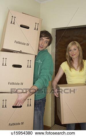 Young couple carrying stack of boxes smiling, portrait View Large Photo Image Stock Image - Young couple carrying stack of boxes smiling, portrait. Fotosearch