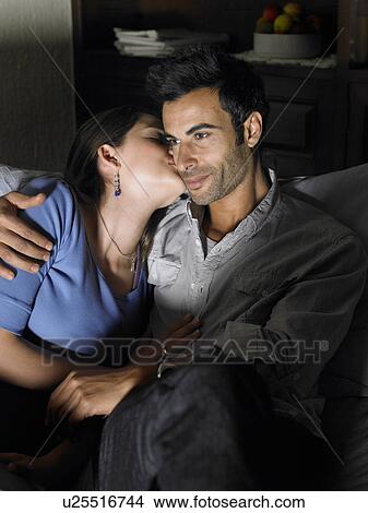 Young couple relaxing on sofa, woman kissing woman View Large Photo Image Picture - Young couple relaxing on sofa, woman kissing woman. Fotosearch
