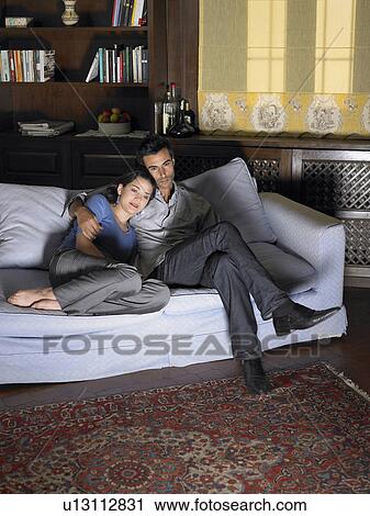 Young couple watching television on sofa. Alicante, Spain. View Large Photo Image Stock Image - Young couple watching television on sofa. Alicante, Spain.. Fotosearch