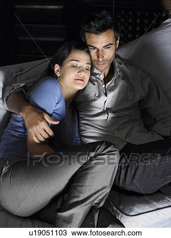 Young couple watching television on sofa, close-up. Alicante, Spain. View Large Photo Image Stock Image - Young couple watching television on sofa, close-up. Alicante, Spain.. Fotosearch