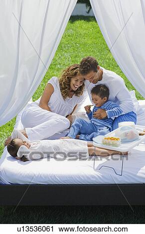 Family having breakfast on bed in garden View Large Photo Image Stock Image - Family having breakfast on bed in garden. Fotosearch