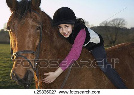Stock Photo - Girl hugging her pony. Fotosearch