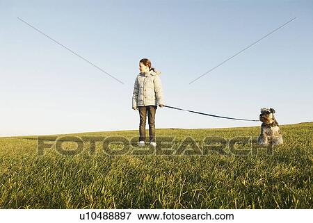 Girl with dog on lead, expanse of sky View Large Photo Image Stock Photo - Girl with dog on lead, expanse of sky. Fotosearch