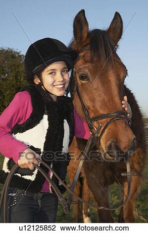 Stock Image - Girl with her pony. Fotosearch