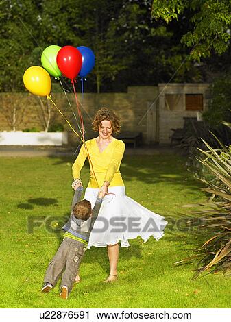 Mother and son playing in garden View Large Photo Image Stock Image - Mother and son playing in garden. Fotosearch