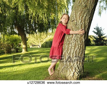Stock Photograph - Young girl hugging tree. Fotosearch