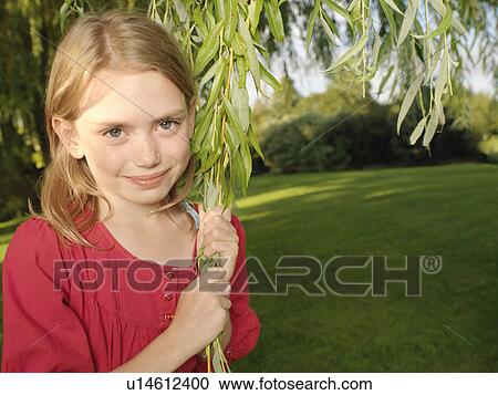 Stock Image - Young girl pulling on branch. Fotosearch