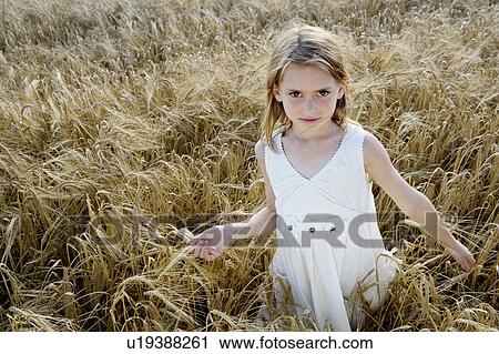 Young girl walking in corn field View Large Photo Image Stock Image - Young girl walking in corn field. Fotosearch