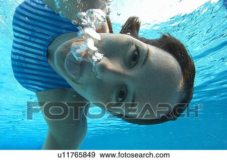 Female swimmer pulling face, portrait, underwater view View Large Photo Image Stock Photo - Female swimmer pulling face, portrait, underwater view. Fotosearch