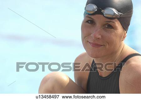 Female swimmer sitting by pool, smiling, portrait, close-up View Large Photo Image Stock Photo - Female swimmer sitting by pool, smiling, portrait, close-up. Fotosearch