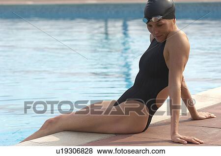 Female swimmer sitting on edge of pool, smiling View Large Photo Image Stock Photo - Female swimmer sitting on edge of pool, smiling. Fotosearch