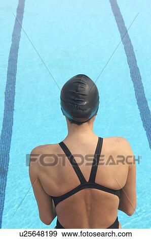 Female swimmer standing in front of pool, rear view View Large Photo Image Stock Photo - Female swimmer standing in front of pool, rear view. Fotosearch