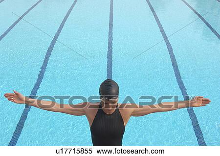 Female swimmer standing with arms outstretched by pool View Large Photo Image Stock Photography - Female swimmer standing with arms outstretched by pool. Fotosearch