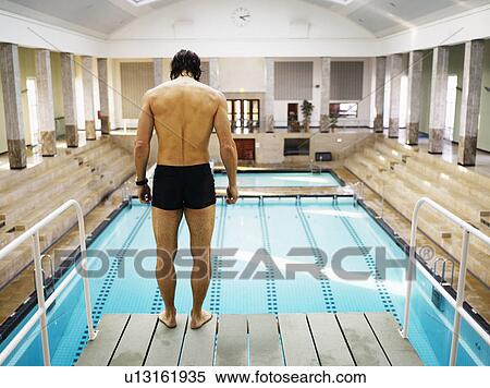 Man standing on diving board, rear view View Large Photo Image Stock Photography - Man standing on diving board, rear view. Fotosearch
