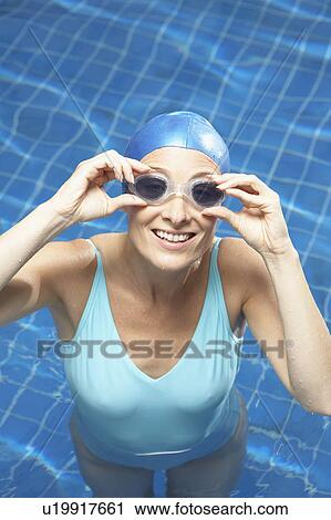 Stock Image - Portrait of woman holding her goggles.. Fotosearch
