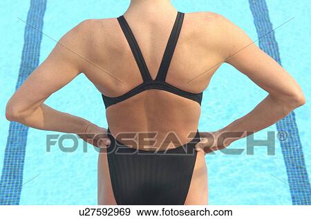 Woman standing in front of swimming pool, rear view View Large Photo Image Stock Photo - Woman standing in front of swimming pool, rear view. Fotosearch